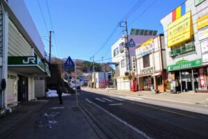 万座・鹿沢口駅北西側出口と駅前通り国道144号線。土産物店が並ぶ。